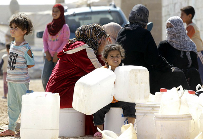 Syrian refugees wait to fill up plastic water containers at the Al-Zaatari refugee camp near the Jordanian city of Mafraq, some 8-kilometres from the Syrian border (AFP Photo / Khalil Mazraawi)