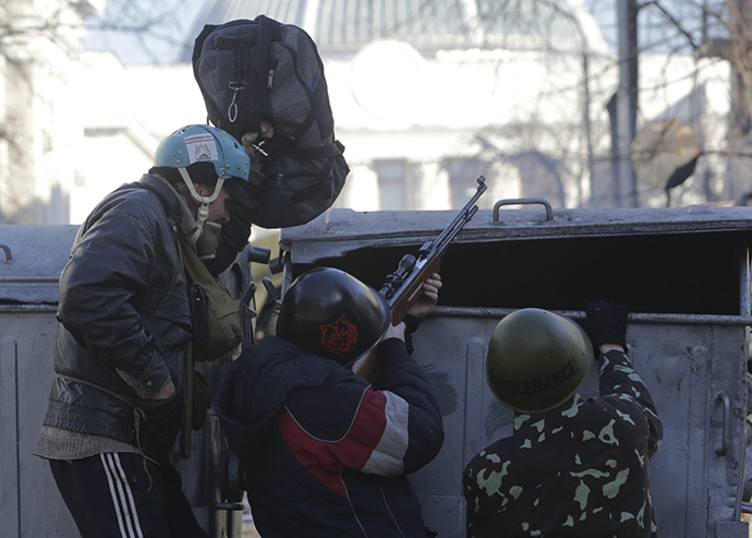 Rioters use a pmeumatic gun as they take cover behind barricades during clashes with police in Kiev February 18, 2014. (Reuters / Konstantin Chernichkin)