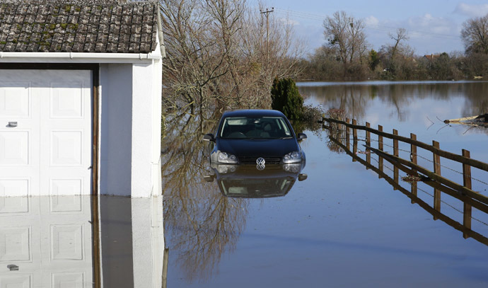 A semi-submerged car is seen in urban landscape taken in the flooded Somerset village of Moorland February 16, 2014. (Reuters)