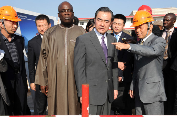 China's Foreign Minister Wang Yi (C), flanked by Senegal's Culture Minister Abdou Azize Mbaye (C-L), visits the construction site of Senegal's Chinese-funded Museum of "Civilisations Noires" (Black civilizations) on January 11, 2014 in Dakar. (AFP Photo)