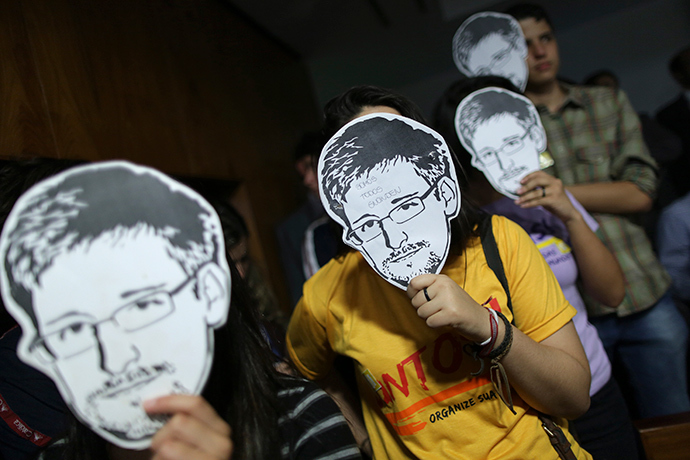 People use masks with pictures of former NSA contractor Edward Snowden masks (Reuters / Ueslei Marcelino)