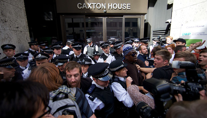 Ranks of police officers disperse protesters against multinational IT firm and Paralympics sponsor Atos from outside the offices of the Department of Work and Pensions in London on August 31, 2012. (AFP Photo)