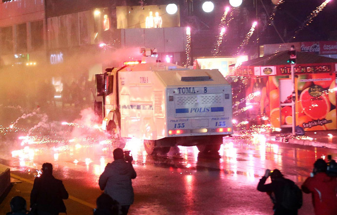 Fireworks thrown by protesters explode near a police water cannon truck as police officers disperse a rally against Turkey's Prime Minister Recep Tayyip Erdogan in Ankara, on March 1, 2014. (AFP Photo / Adem Altan) 