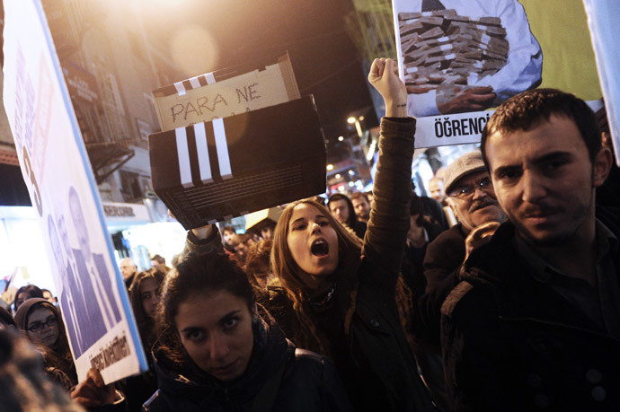 Protestors chant slogans and hold up shoe boxes as they march to the entrance of a Halkbank bank branch in the Besiktas district of Istanbul on December 19, 2013.( AFP Photo / Ozan Kose)