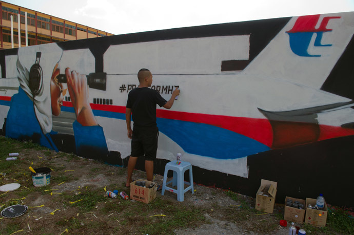A member from Super Sunday, Zulkifli Salleh works on a graffiti featuring the missing Malaysia Airlines flight MH370 displayed on a wall in Kuala Lumpur on March 24, 2014. (AFP Photo)
