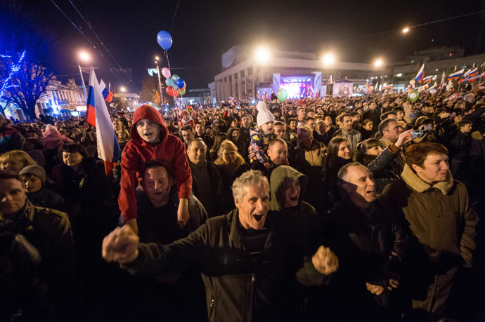 People wave Russian flags and cheer in the center of the Crimean city of Simferopol on March 21, 2014. (AFP Photo)