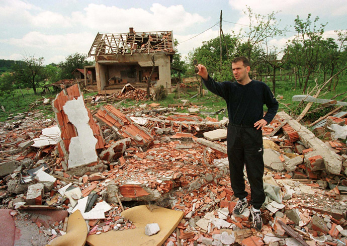 Vladan Lukic, a leading Yugoslav soccer player, shows a destroyed house, where Stevan (8) and Dajana Pavlovic (7) were killed during recent NATO bombing in Ralja near Belgrade June 26, 1999 (Reuters)