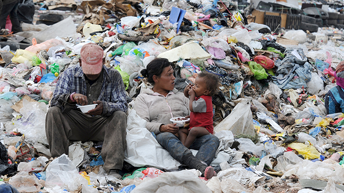 A couple and their child have breakfast amid the garbage at the municipal rubbish dump, 20 km north of Tegucigalpa, Honduras. (AFP Photo / Orlando Sierra)