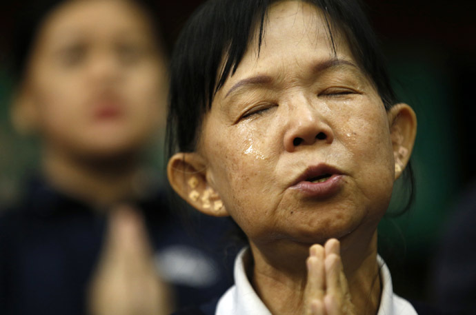 A Taiwanese volunteer assisting relatives of passengers on board Malaysia Airlines MH370 cries as she prays for the passengers at the Lido Hotel in Beijing April 1, 2014. (Reuters)