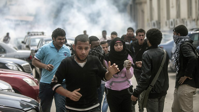 Egyptian students, supporters of the Muslim Brotherhood and ousted Islamist president Mohamed Morsi, run for cover as tear gas is fired by Egyptian riot police during clashes following a demonstration outside Cairo University, on April 9, 2014. (AFP Photo / Mahmoud Khaled)