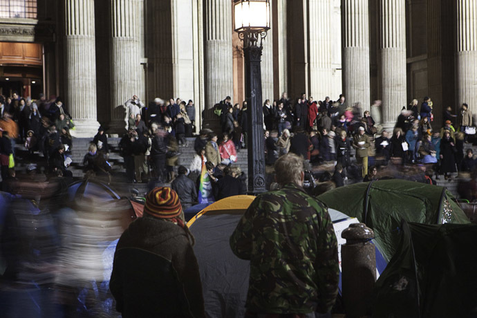 Occupy London Stock Exchange protestors watch as people leave a Christmas eve carol service at St Pauls Cathedral in London December 24, 2011. (Reuters)