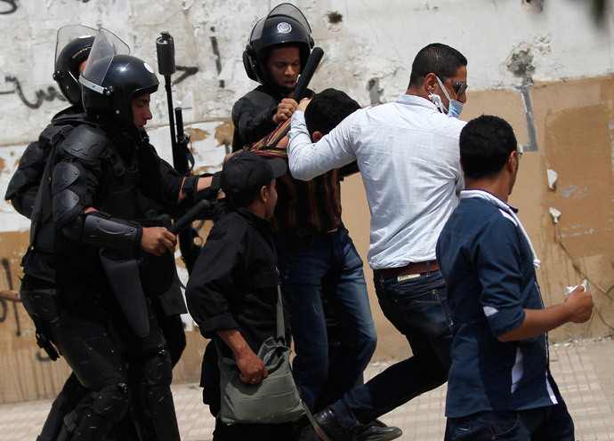 Riot police and a plainclothes policeman detains a student, who is a supporter of Muslim Brotherhood and ousted President Mohamed Mursi, during a protest against the military and the interior ministry, at Al-Azhar University in Cairo's Nasr City district, April 16, 2014. (Reuters / Amr Abdallah Dalsh)