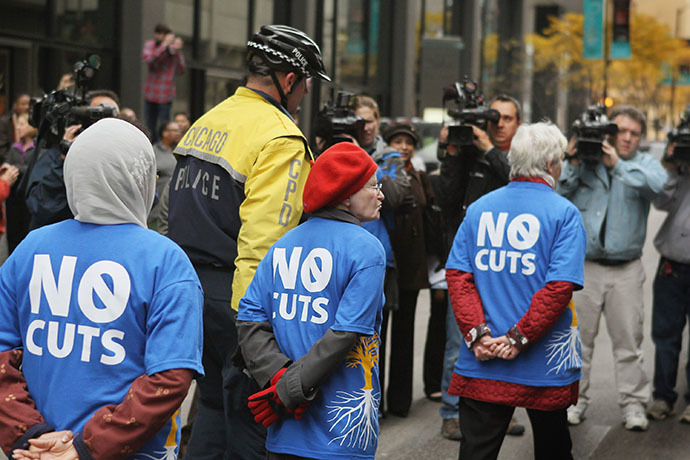Demonstrators are led away by police during a protest against cuts to federal safety net programs, including Social Security, Medicare, and Medicaid on November 7, 2011 in Chicago, Illinois. (AFP Photo / Getty Images / Scott Olson)