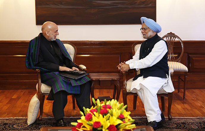Indian Prime Minister Manmohan Singh (R) talks to Afghan President Hamid Karzai at his residence in New Delhi on December 13, 2013. (AFP Photo / Saurabh Das)