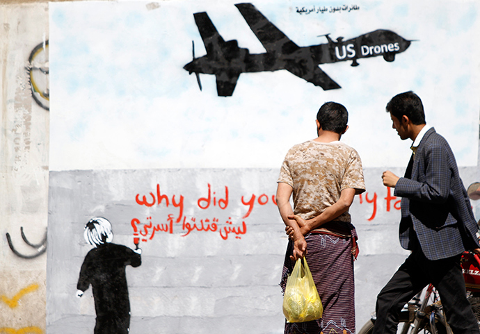 Men look at wall graffiti depicting a U.S. drone along a street in Sanaa (Reuters / Mohamed al-Sayaghi)