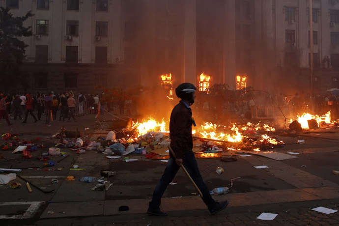 A protester walks past a burning tent camp and a fire in the trade union building in Odessa May 2, 2014. (Reuters/Yevgeny Volokin)