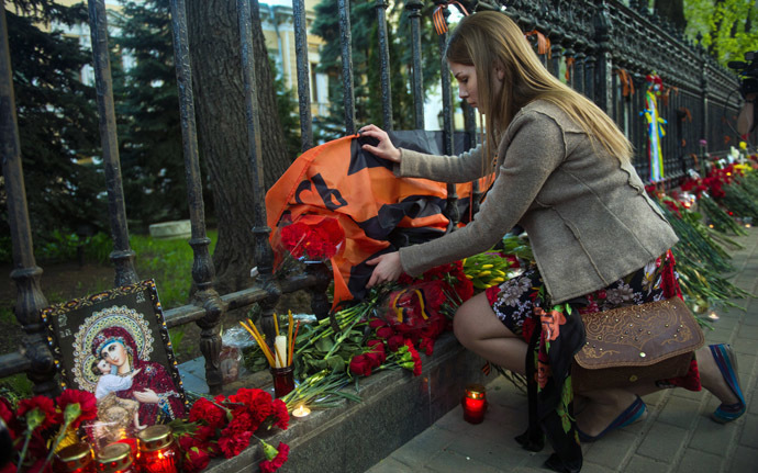 A woman lays flowers by the fence of the Ukrainian embassy in Moscow on May 3, 2014, in honor of people killed during clashes in Odessa. (AFP Photo)