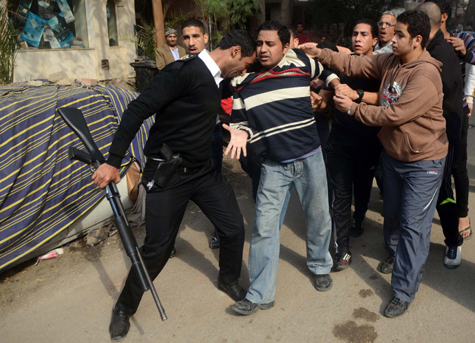 An Egyptian policeman arrests a Muslim Brotherhood supporter (C) following a demonstration in the Nasr City district of Cairo, on January 25, 2014. Egyptian police fired tear gas at anti-government protesters in Cairo, as the country marked the anniversary of a 2011 uprising that overthrew veteran president Hosni Mubarak. (AFP Photo / Mohamed El-Shahed)
