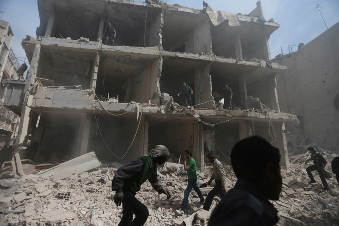 Civilians and rescuers are seen at a site hit by what activists said was a warplanes attack by forces loyal to Syrian President Bashar al-Assad in the Duma neighbourhood of Damascus April 13, 2014 (Reuters / Bassam Khabieh)