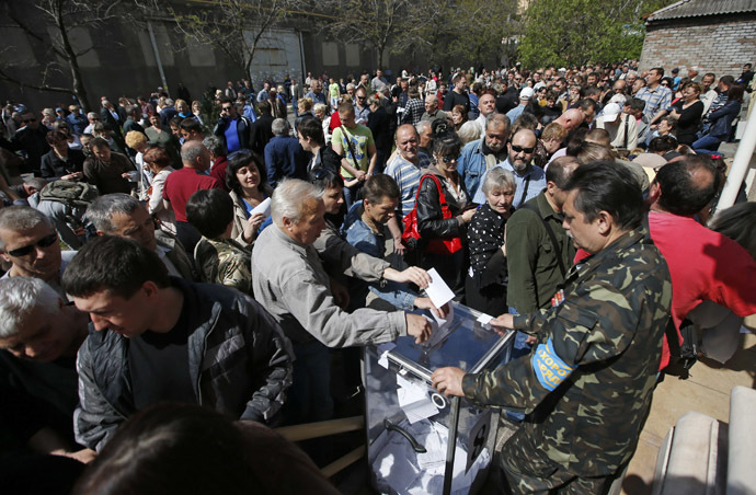 People stand in a line to cast ballots into a portable ballot box during the referendum on the status of Donetsk region in the eastern Ukrainian city of Mariupol May 11, 2014. (Reuters/Marko Djurica)
