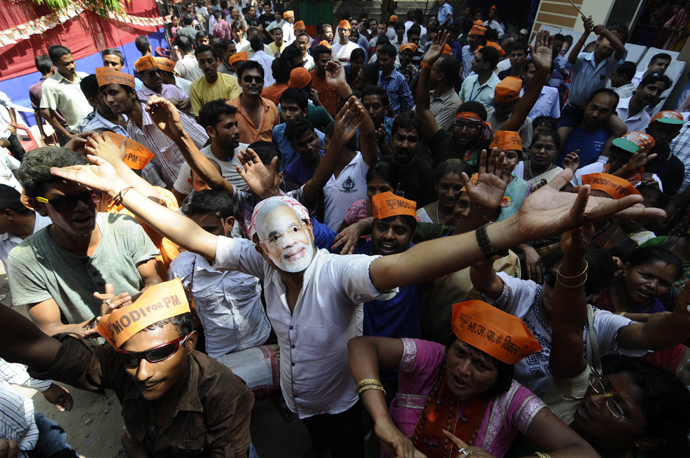 A Bharatiya Janata party (BJP) worker wears a mask of BJP prime ministerial candidate Narendra Modi as they celebrate outside the party office in Guwahati on May 16, 2014 (AFP Photo / Biju Boro)
