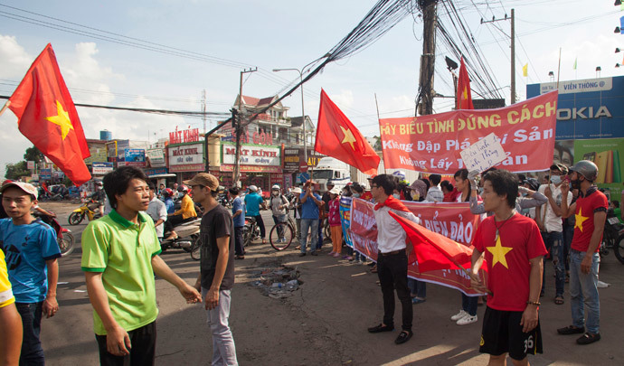 Workers wave Vietnamese national flags during a protest at an industrial zone in Binh Duong province May 14, 2014. (Reuters / Stringer )