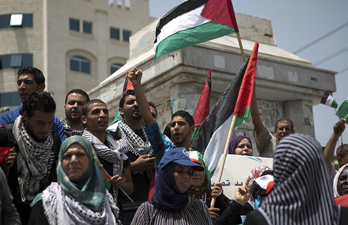 Palestinian protesters chant slogans to speed up the implementation of the national reconciliation and the announcement of the formation of a national unity government, during a rally in Gaza City on May 27, 2014. (AFP Photo / Mohammed Abed)