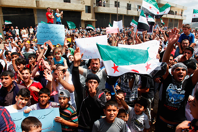Syrian refugees carrying Free Syrian Army flags attend a protest against the election of Syrian President Bashar Al-Assad in Tripoli June 1, 2014 (Reuters / Omar Ibrahim)