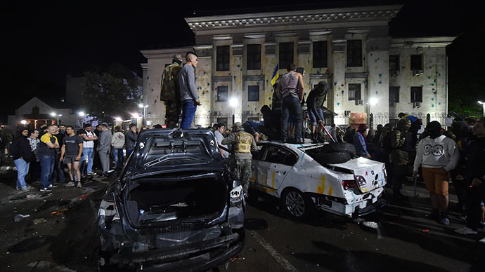 Protesters stand on top of the crashed cars during a rally against the Russian President Vladimir Putin in front of the Russian embassy in Kiev on June 14, 2014. (AFP Photo / Sergei Supinsky)