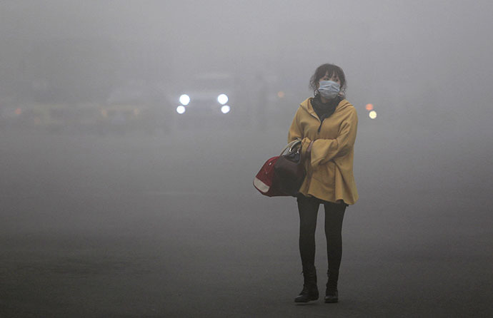 A woman wearing a face mask walks in heavy smog in Harbin, northeast China's Heilongjiang province, on October 21, 2013. (AFP Photo)