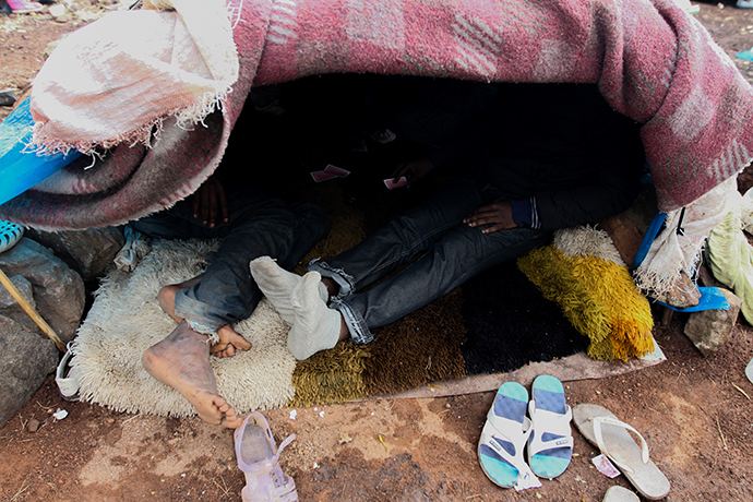 Two migrants playing cards in a tent renamed the âcasinoâ of Gurugu. Photo by @TomasoClavarino