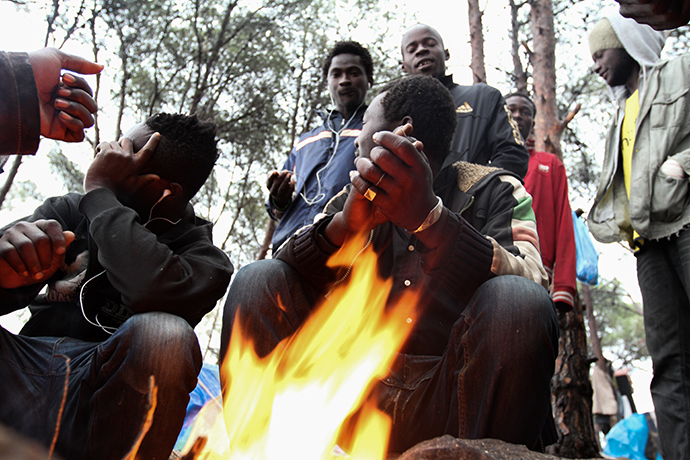 A group of Malian migrants trying to keep warm with a bonfire in the forest on the slopes of Gurugu. Photo by @TomasoClavarino