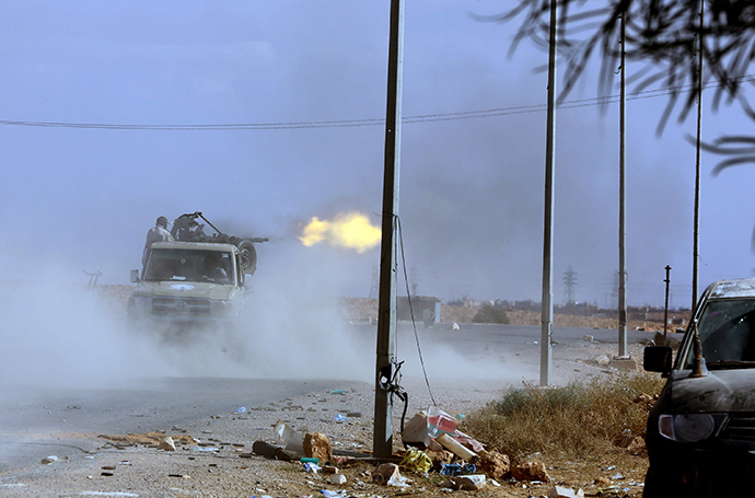 Pro-government forces fire their gun off the back of a truck on October 23, 2012, one kilometer from the northern entrance to the town of Bani Walid, one of the final bastions of Moamer Kadhafi's ousted regime (AFP Photo)