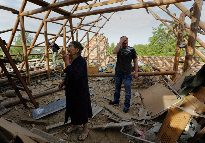 Roza Gerasimenko,79, surveys the damage in her home following what locals say was overnight shelling by Ukrainian forces in the outskirts of the eastern Ukrainian town of Slaviansk May 20, 2014. (Reuters/Yannis Behrakis)