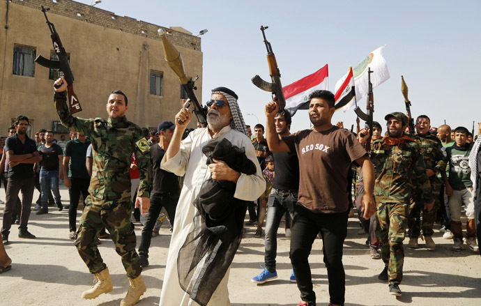 Volunteers, who have joined the Iraqi Army to fight against predominantly Sunni militants, carry weapons during a parade in the streets in Baghdad's Sadr city June 14, 2014. (Reuters/Ruben Sprich)