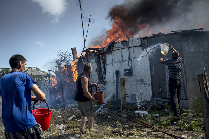 Local residents put out the fire in a house damaged by an air strike by the Ukrainian armed forces on the village of Luganskaya. (RIA Novosti)