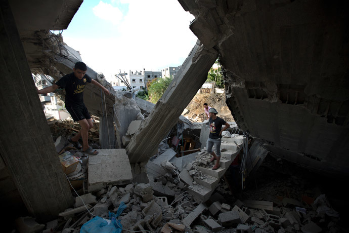Palestinians inspect a destroyed building following an Israeli military strike on Beit Lahya, northern Gaza Strip on July 15, 2014. (AFP Photo / Mahmud Hams) 