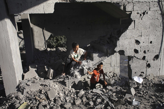 Palestinian boys are seen in a damaged house as they look at the remains of a neighboring house which police said was destroyed in an Israeli air strike in Rafah in the southern Gaza Strip July 16, 2014. (Reuters)