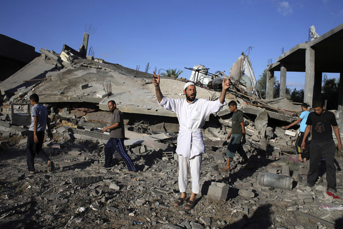 A Palestinian man gestures as he speaks to members of the media in front of a house which police said was destroyed in an Israeli air strike in Rafah in the southern Gaza Strip July 16, 2014. (Reuters)