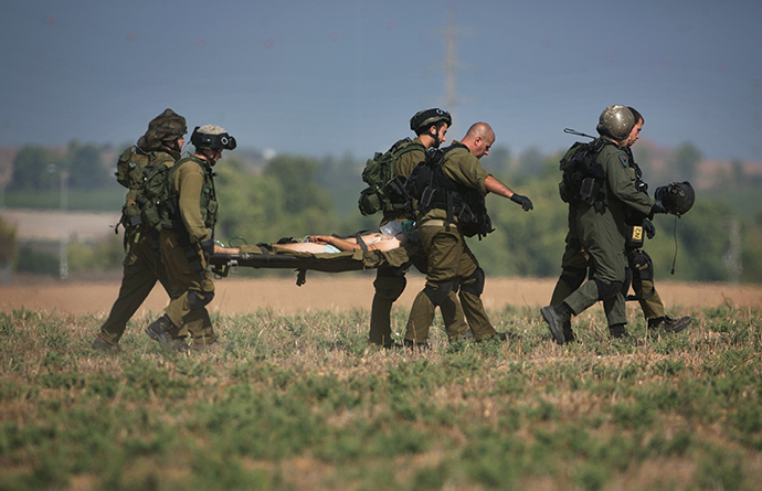 An injured Israeli soldier is evacuated from near the Israeli border with Gaza Strip on July 21, 2014, following heavy fights between Israeli soldiers to Palestinian militants. (AFP Photo / Menahem Kahana)