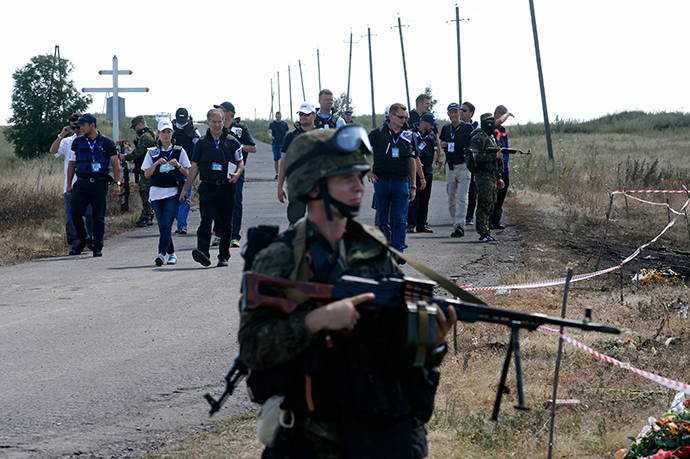 Monitors from the Organization for Security and Cooperation in Europe (OSCE) and members of a forensic team visit the crash site of Malaysia Airlines Flight MH17 near the village of Hrabove (Grabovo), Donetsk region July 21, 2014 (Reuters / Maxim Zmeyev)
