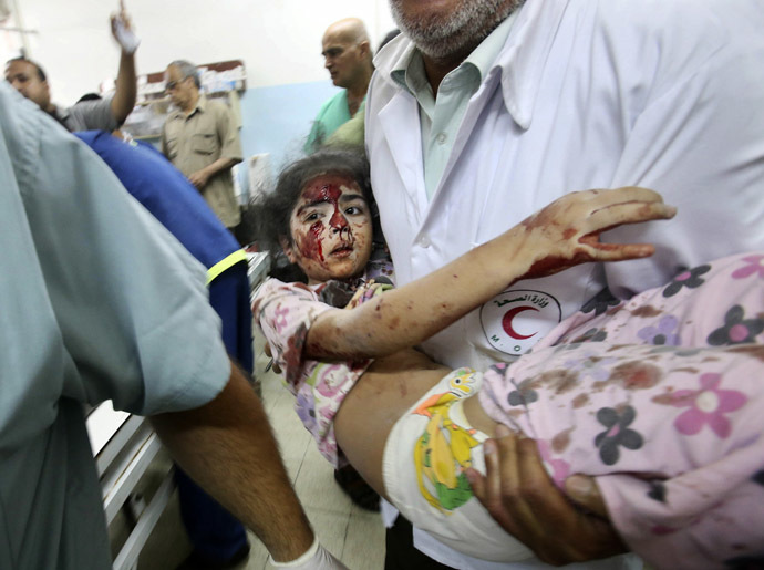 A Palestinian medic carries a girl, who medics said was wounded by Israeli shelling, at a hospital in Khan Younis in the southern Gaza Strip July 23, 2014. (Reuters)
