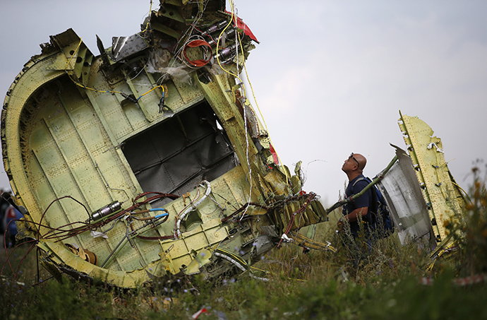 A Malaysian air crash investigator inspects the crash site of Malaysia Airlines Flight MH17, near the village of Hrabove (Grabovo), Donetsk region July 22, 2014. (Reuters / Maxim Zmeyev)