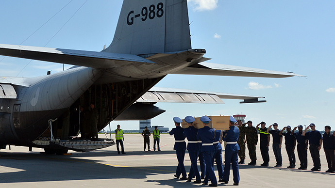 Ukrainian soldiers carry a coffin with the remains of a victim of the Malaysia Airlines flight MH17 crash to a military plane during a ceremony at the airport of Kharkiv, Ukraine, on July 23, 2014 (AFP Photo / Genya Savilov)