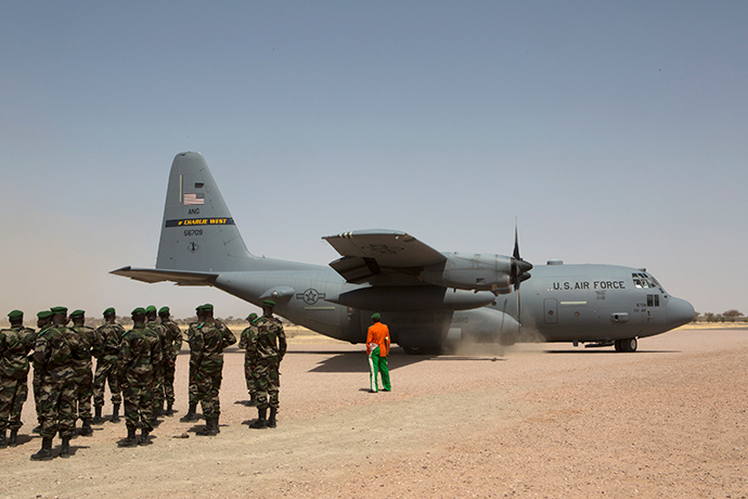 A C-130 U.S. Air Force plane lands as Nigerien soldiers stand in formation during the Flintlock military exercise in Diffa, March 8, 2014 (Reuters / Joe Penney)