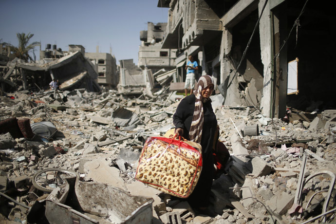 A Palestinian woman carries her belongings from her destroyed house in the Shejaia neighborhood, which witnesses said was heavily hit by Israeli shelling and air strikes during an Israeli offensive, in the east of Gaza City August 1, 2014. (Reuters/Mohammed Salem)