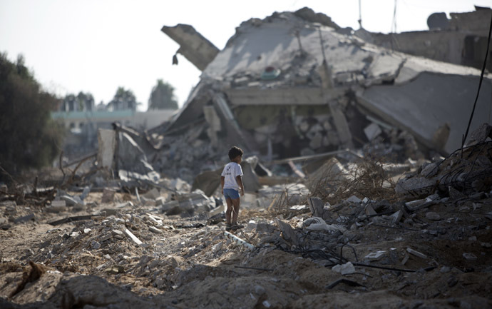 A Palestinian boy walks over debris as civilians who were displaced from their houses due to fighting between Israel's army and Hamas fighters return to check their homes in Gaza City's Shejaiya neighbourhood, on August 1, 2014. (AFP Photo)