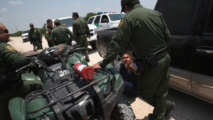 Border Patrol agents detain a suspected smuggler after he allegedly transported undocumented immigrants who crossed the Rio Grande from Mexico into the United States on July 24, 2014 in Mission, Texas.(AFP Photo / John Moore)