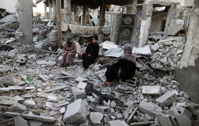 Palestinians sit outside their destroyed house in Beit Hanoun town, which witnesses said was heavily hit by Israeli shelling and air strikes during the Israeli offensive, in the northern Gaza Strip August 7, 2014. (Reuters)