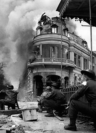 British troops are seen crouching against German snipers action in Arnhem on April 15, 1945 a few weeks before the end of World War II (AFP Photo)